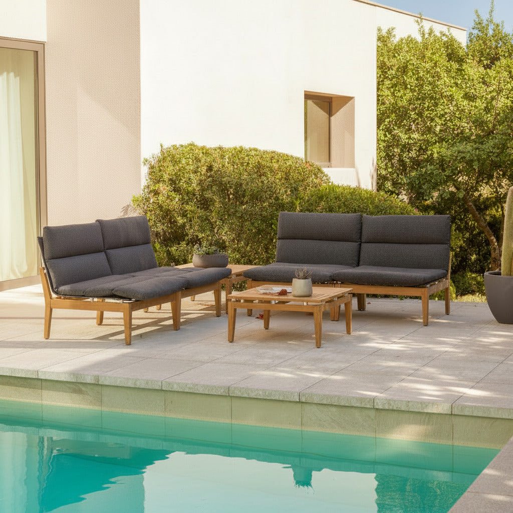Outdoor patio furniture set with dark cushions by a poolside.