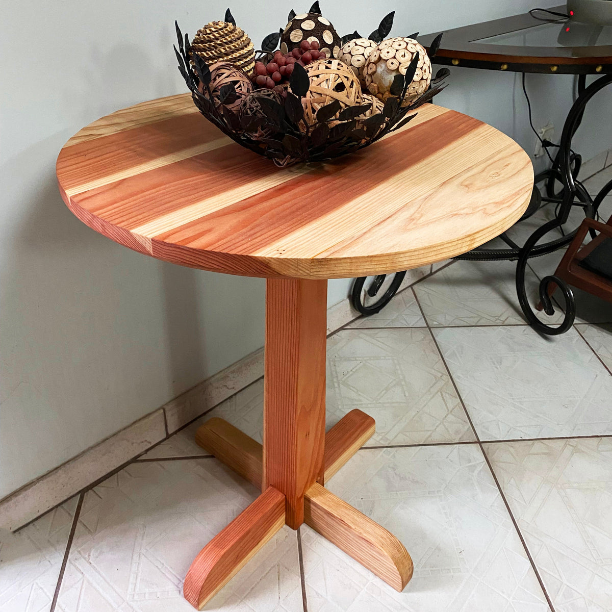Wooden side table with a decorative bowl on a tiled floor