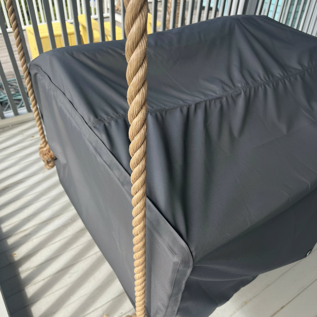 Gray swing cover accessory for a teak porch swing