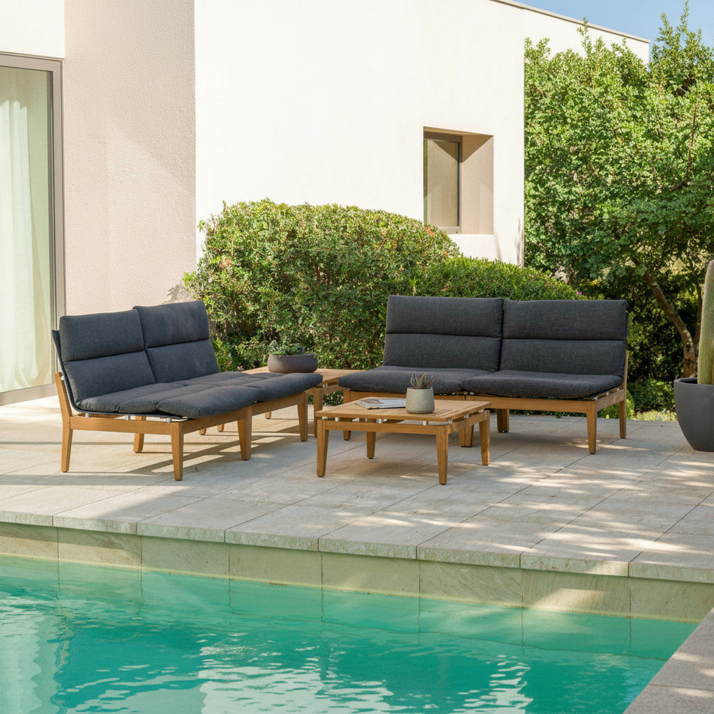 Outdoor patio furniture set with dark cushions by a poolside.