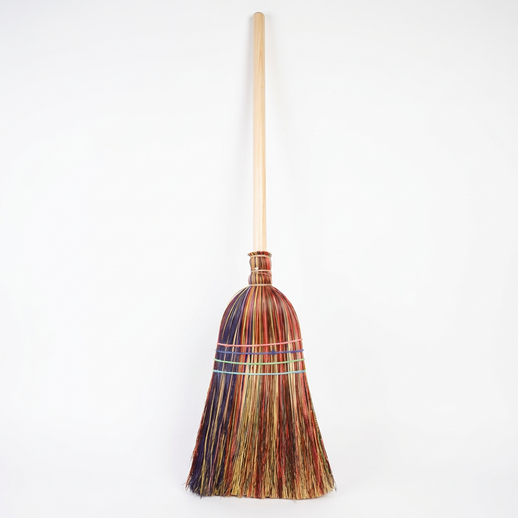 Multicolored broom with wooden handle on a white background