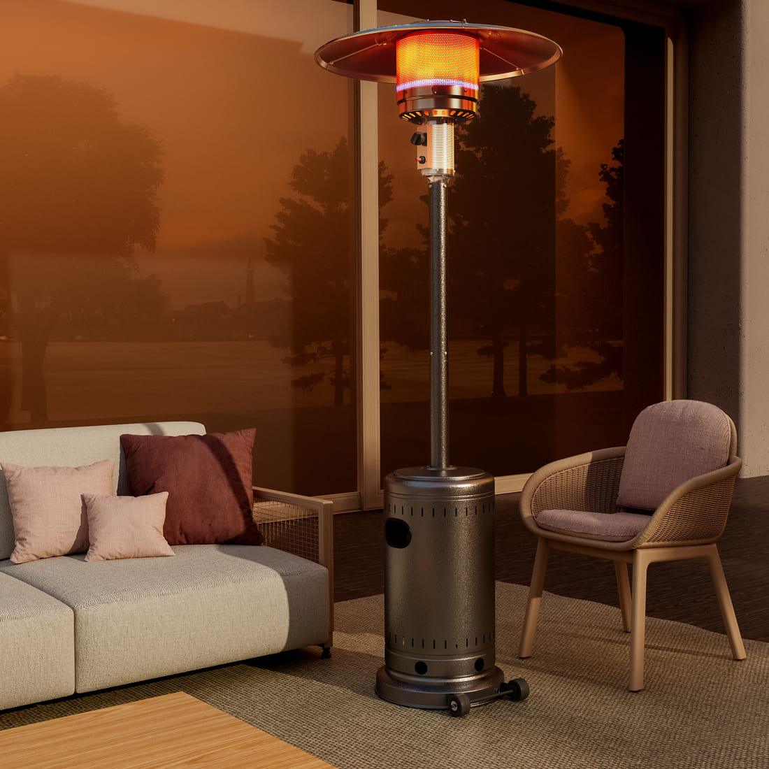 Outdoor patio heater on a patio with furniture and a sunset view.